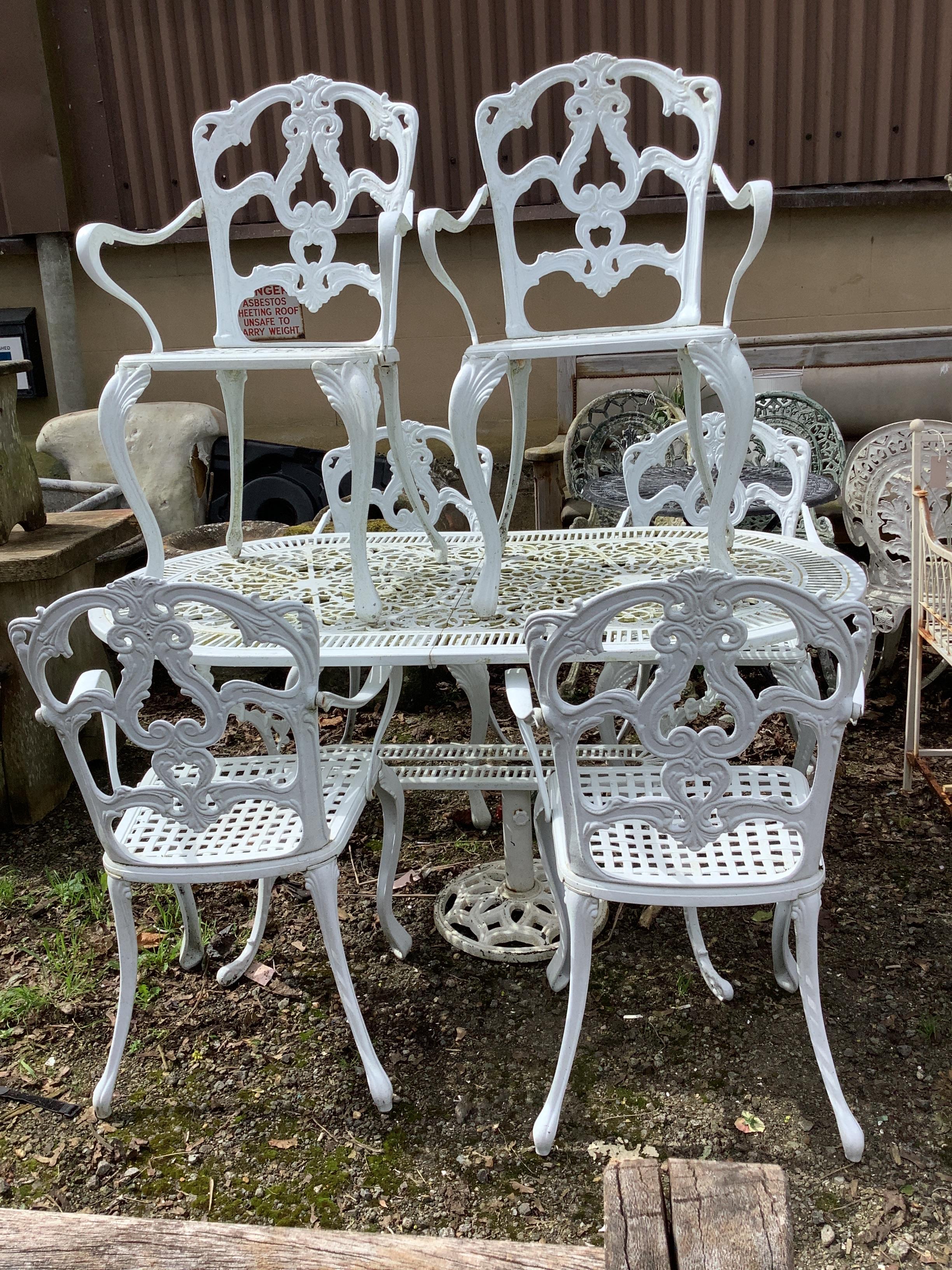 A Victorian style painted aluminium garden table, width 142cm, depth 80cm, height 71cm and six similar painted armchairs and a parasol base